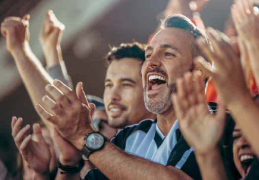 Men in a crowd cheering.