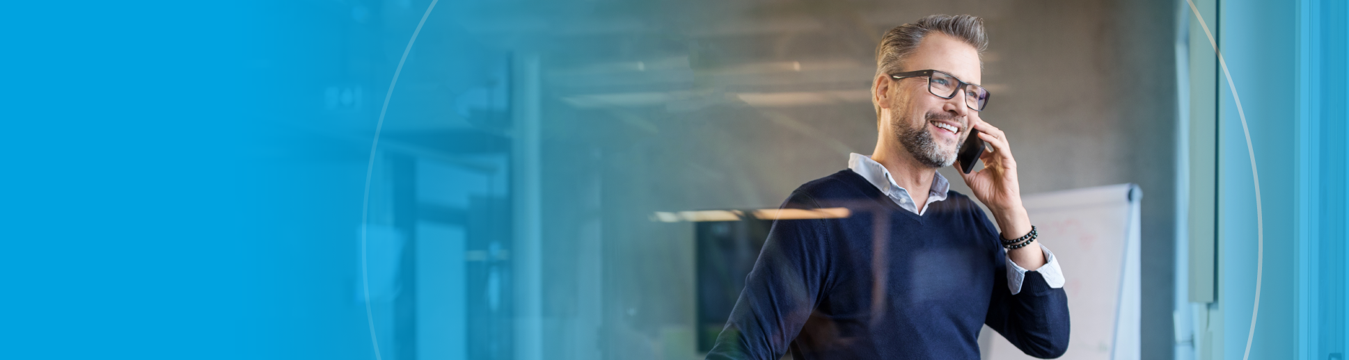 Man wearing blue sweater talking on the phone