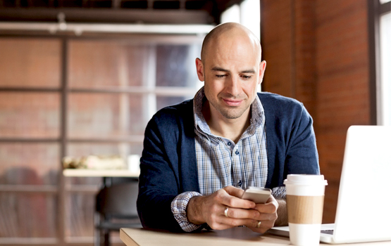 Man in coffee shop looking at phone