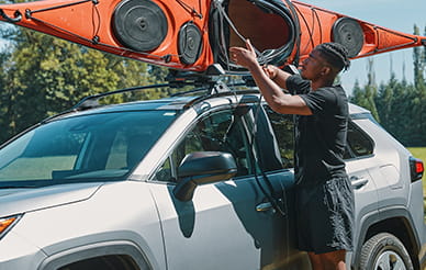 Man taking kayak off car