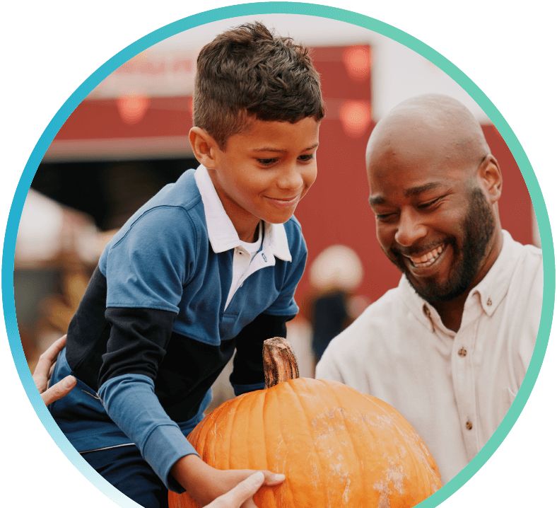 Father and son holding a pumpkin.