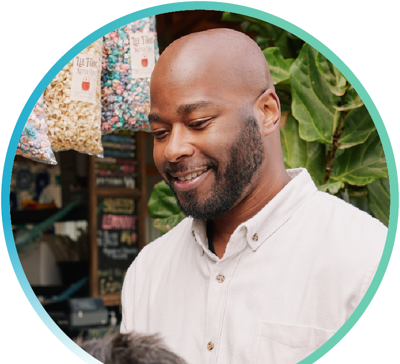 Image of a man smiling while shopping at what appears to be an outdoor shop.