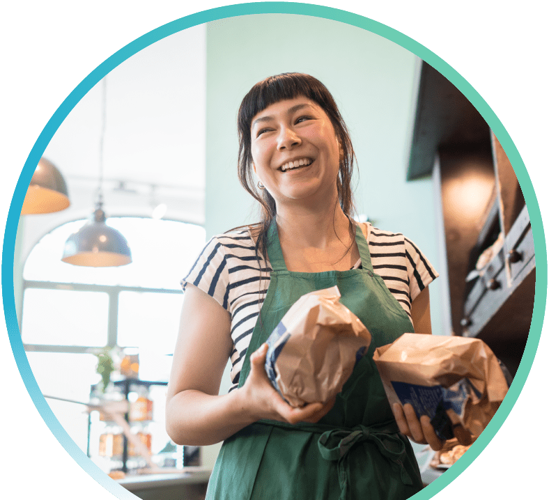 Person smiling, holding items in both hands
