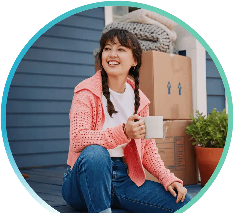 Woman sitting on a couch opening a box.