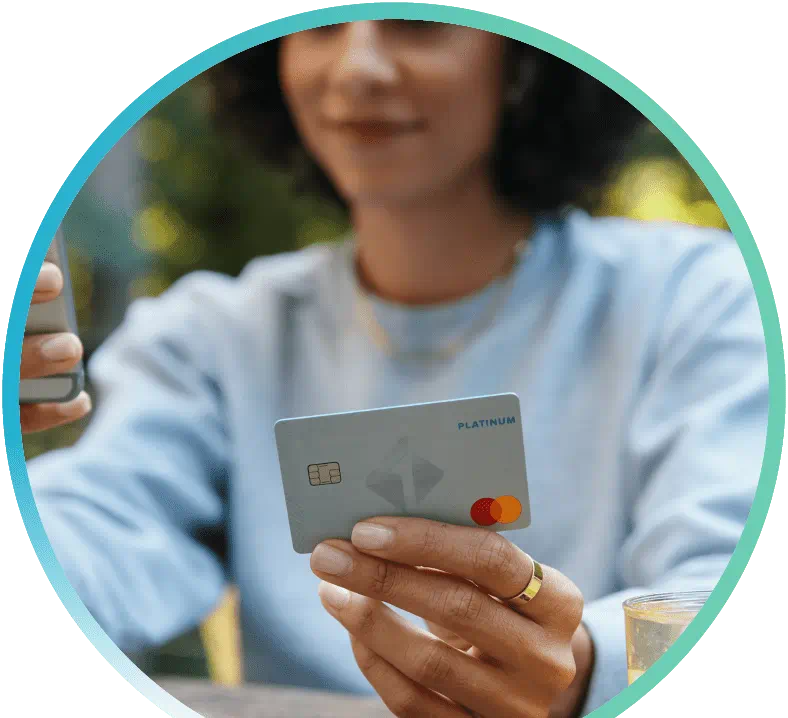 Woman holding Platinum Rewards Card while browsing on their phone.