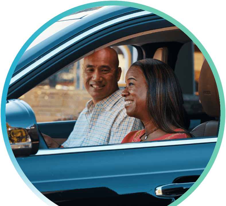 Two people smiling in their car.