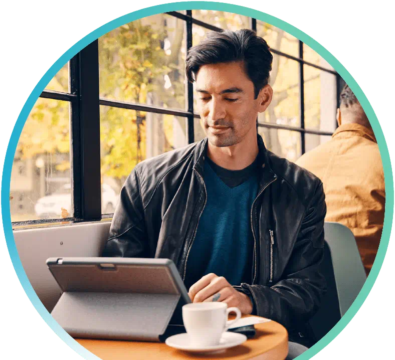 Man browsing on their tablet in a coffee shop.