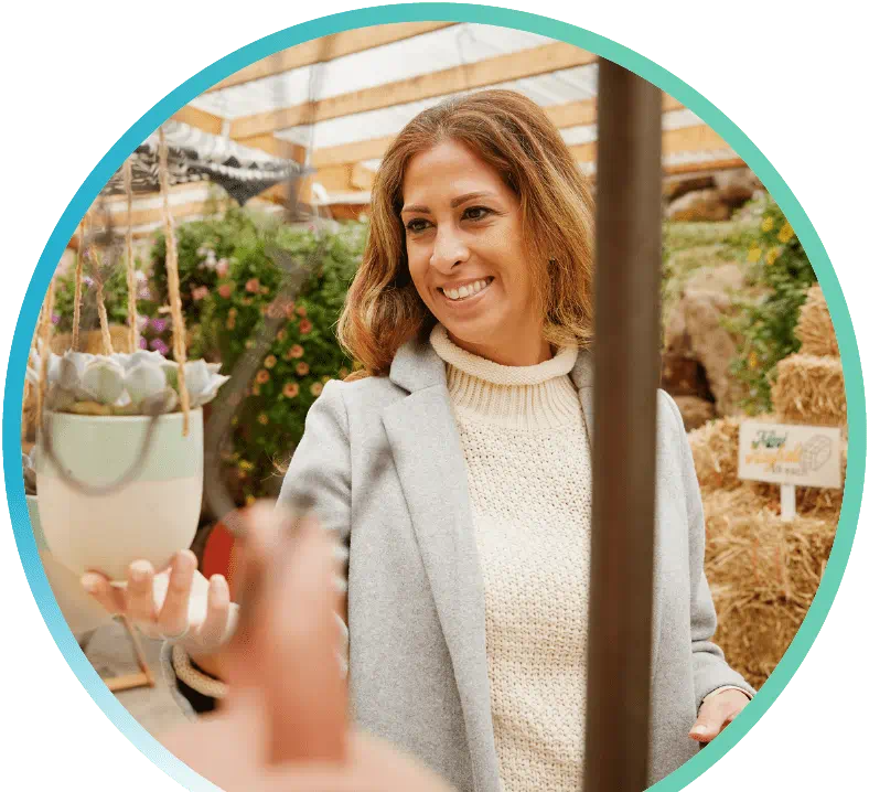 Woman holding a flower pot in a botanical shop.