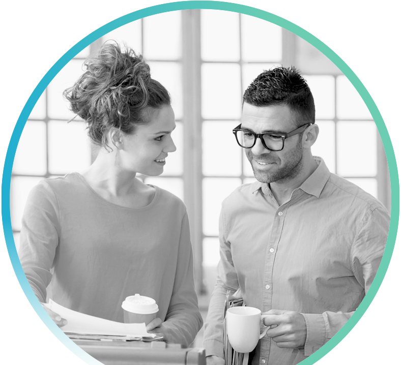 Two people drinking coffee while looking over paperwork together