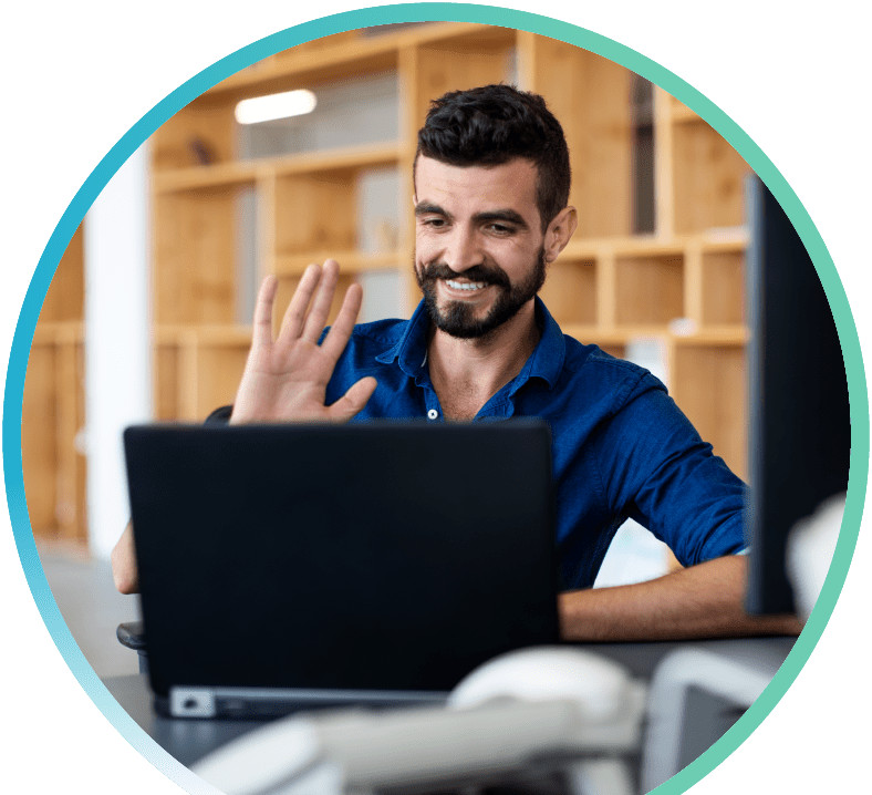 Man waving at his laptop camera while on a video call.