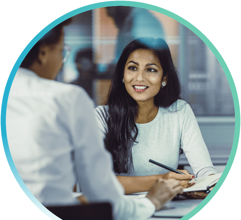 Woman sitting down with a banker and taking down notes.