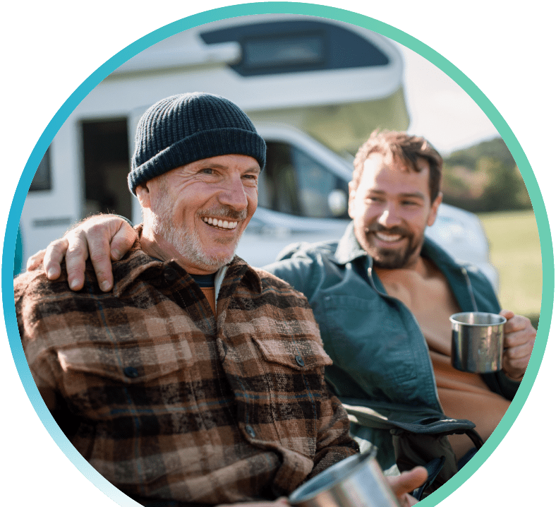 Two men sitting outside in front of an RV.