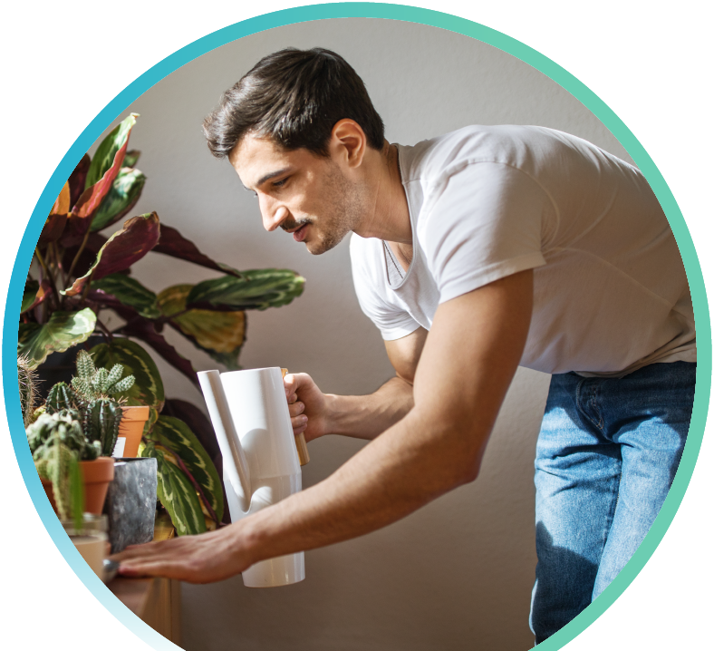 Man watering their indoor plants.