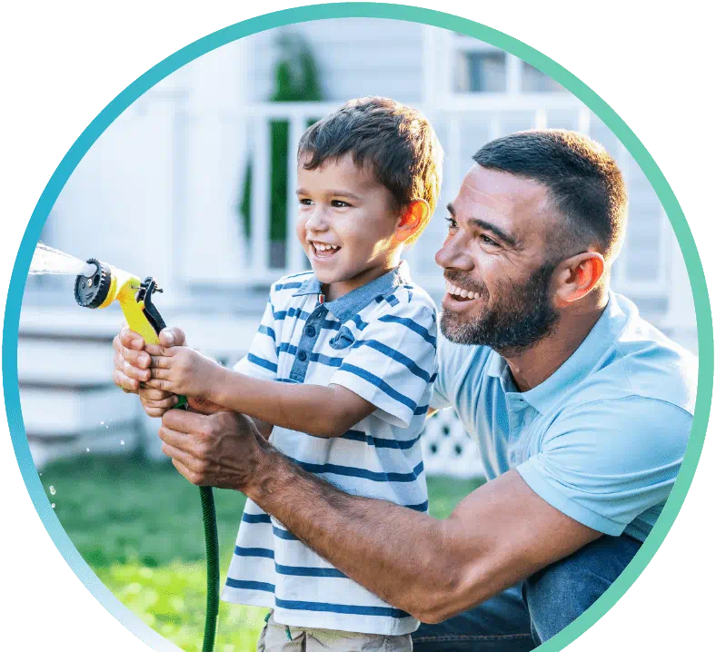 Man and a child holding a water hose