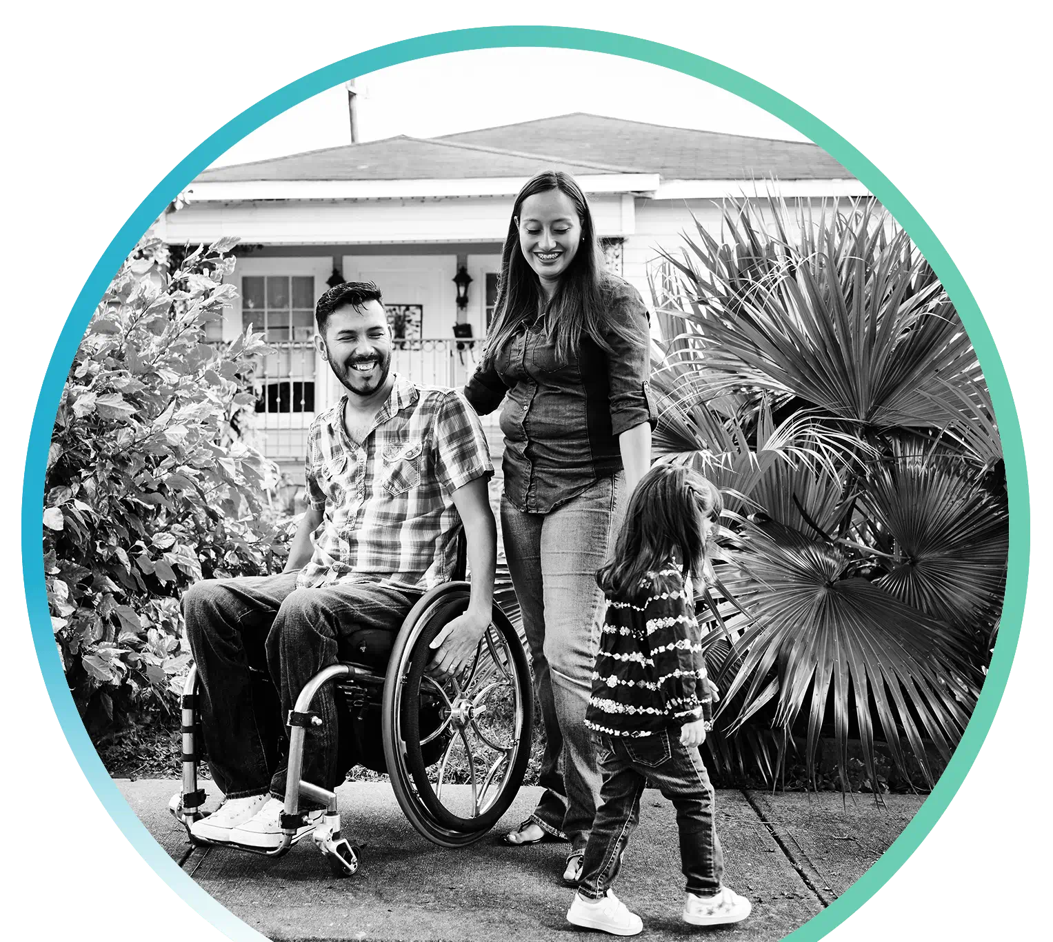A person in a wheelchair with their partner and child spending time together outside
