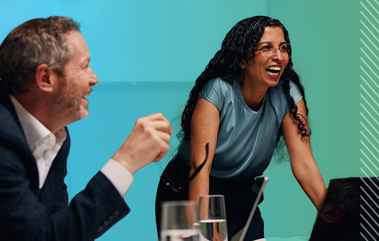 Two business professionals are pictured at a meeting table.
