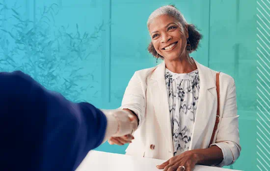 A woman is shaking the hand of an insurance agent.