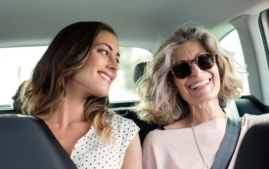 Mother and daughter smiling in car