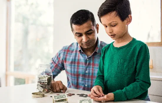 Father and son counting money at a table