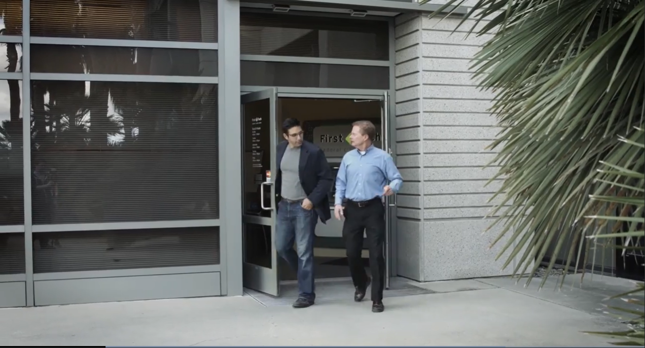 Brett Everhart and a client in front of First Tech location